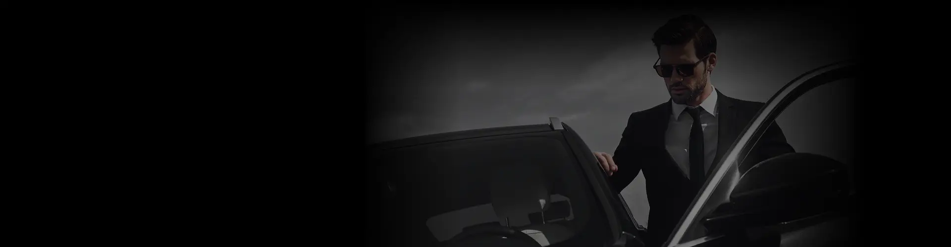 A man in a black suit opening a luxury car door from a side angle, representing Partners joining the Prestige Ride network.