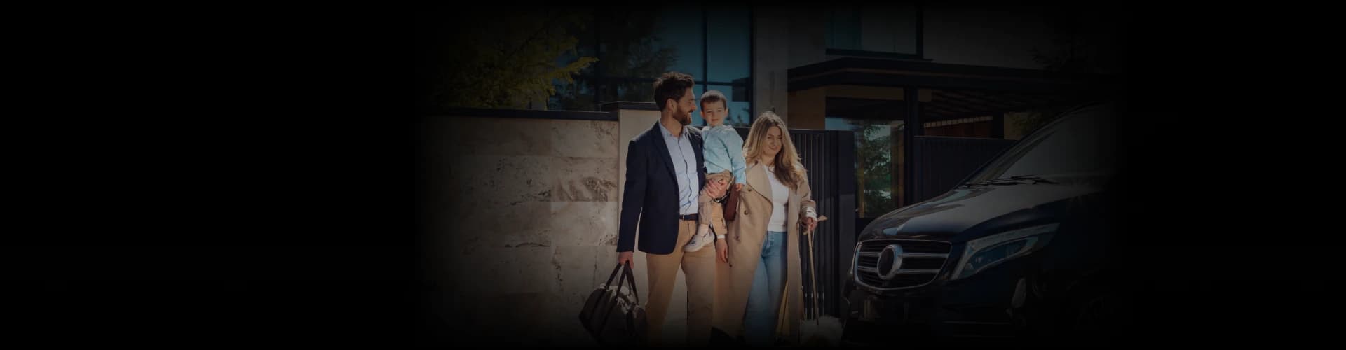 A family with luggage stepping out of a modern home toward a luxury black van, captured from a warm front angle under soft daylight, symbolizing a premium travel experience.