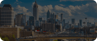 Downtown Atlanta with traffic, tall buildings, and a cloudy backdrop.