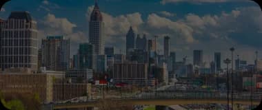 Downtown Atlanta with traffic, tall buildings, and a cloudy backdrop.