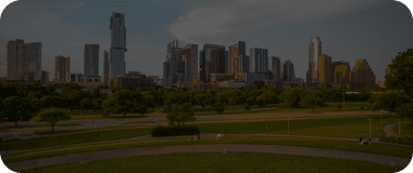 Austin city skyline with a green park and warm sunlight.
