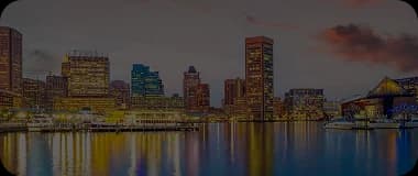 Baltimore skyline with Inner Harbor and historic buildings under a clear sky.