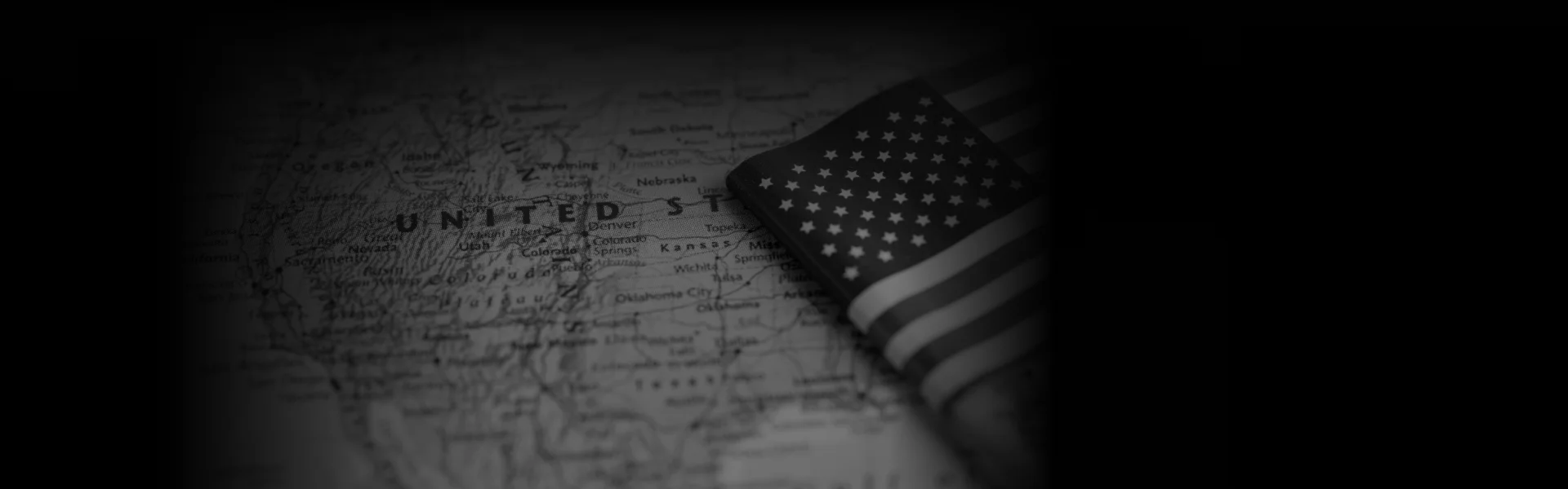 A grayscale map of the United States with a folded American flag placed over the Midwest, accompanied by the text "Premium Transportation Services Across All States" in bold white letters at the bottom.